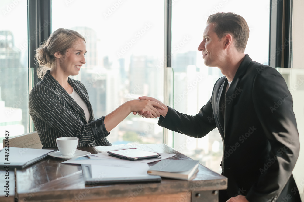 Two businessman and businesswoman couple meeting in co working space or office Two businessman and businesswoman couple meeting in co working space or office