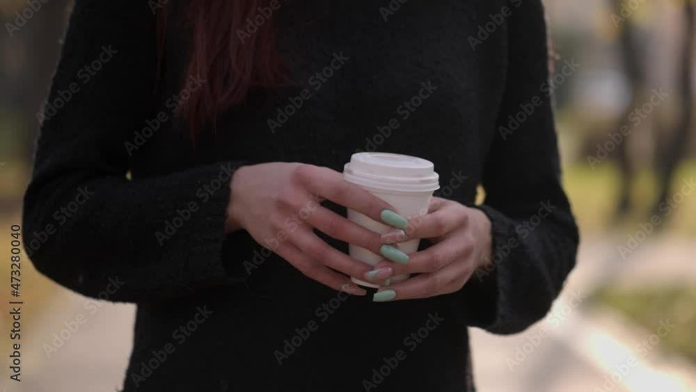 coffee to go. coffee. latte. coffee drink. close-up. female hands hold a disposable cup with a plastic lid , during a beautiful sunset coffee to go. coffee. latte. coffee drink. close-up. female hands hold a disposable cup with a plastic lid , during a beautiful sunset