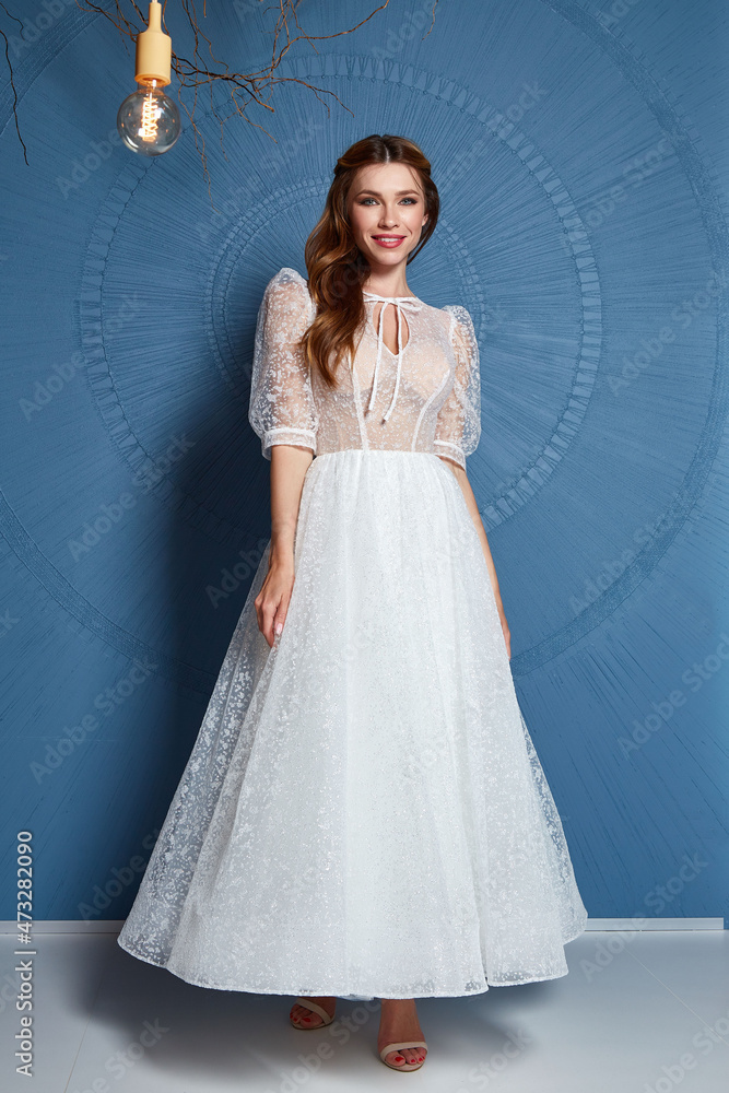 Beautiful tender young woman sexy brunette bride in a luxury white wedding dress lace chiffon Summer happiness awaits the groom before the wedding ceremony makeup accessory jewelry smile. Beautiful tender young woman sexy brunette bride in a luxury white wedding dress lace chiffon Summer happiness awaits the groom before the wedding ceremony makeup accessory jewelry smile.