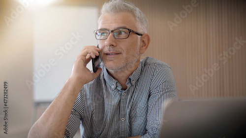 Εκτύπωση καμβά 40 year old man with glasses on the phone in an office