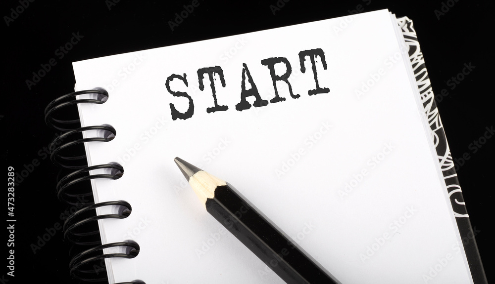 START written text in small notebook on a black background START written text in small notebook on a black background