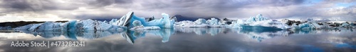 Ultra wide panorama of the Jokulsarlon Glacial lagoon  Southern Iceland. Mirror reflection of the blue ice icebergs.