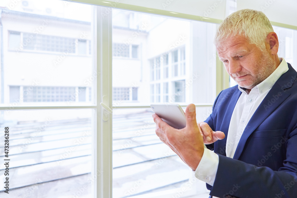 Fototapeta premium Business Mann mit Tablet PC nutzt eine App
