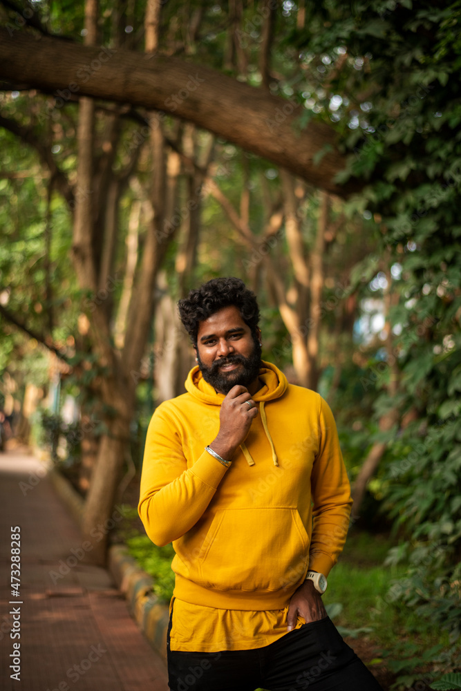Handsome male model in a public park, Indian male model with green background Handsome male model in a public park, Indian male model with green background