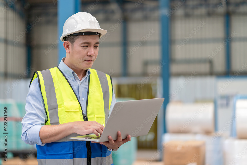 Asian male supervisor engineer hold laptop working at warehouse factory Asian male supervisor engineer hold laptop working at warehouse factory