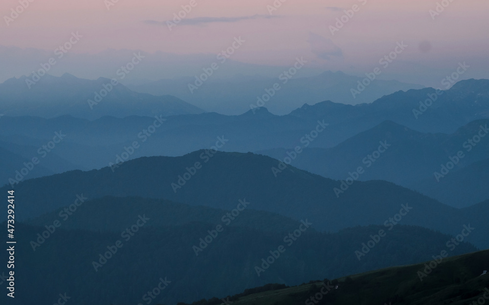 Mountain silhouette layers in the sunset light. Beautiful photography of the nature, blue layered background. Natural gradient.