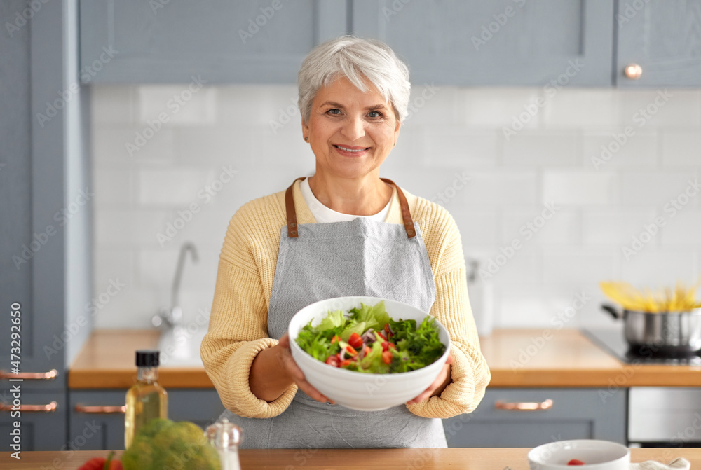 healthy eating, food cooking and culinary concept - happy smiling senior woman making vegetable salad on kitchen at home healthy eating, food cooking and culinary concept - happy smiling senior woman making vegetable salad on kitchen at home