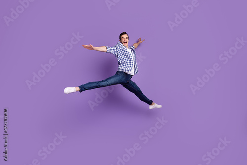 Full body profile side photo of young handsome man have fun jump up isolated over violet color background