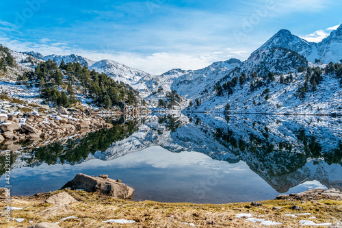 Reflection of the snowy mountains in the beautiful Baciver lake in the Pyrenees mountains of Val d'Aran (Aran Valley), Lleida, Catalonia, Spain