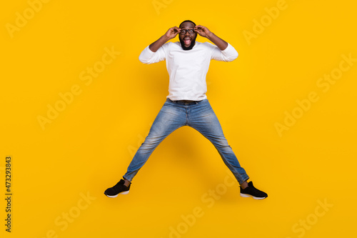 Full size photo of overjoyed astonished guy hands touch glasses open mouth isolated on yellow color background