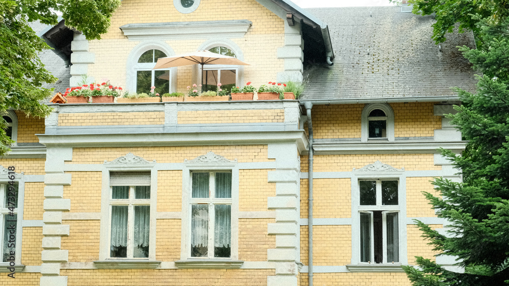 Fototapeta premium Yellow Old Brick Stone Building With Balcony