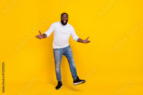 Full body photo of satisfied carefree person arms palms enjoy free time toothy smile isolated on yellow color background