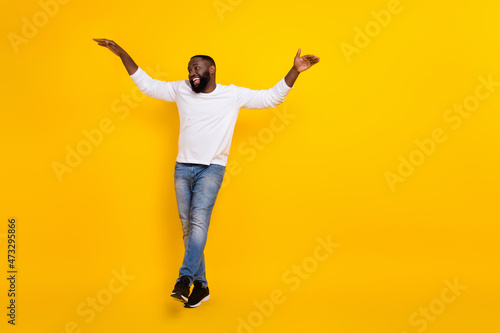 Full size portrait of excited crazy young man partying clubbing spend pastime isolated on yellow color background