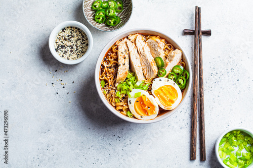 Asian noodle soup ramen with chicken and egg in gray bowl. Japanese food concept.