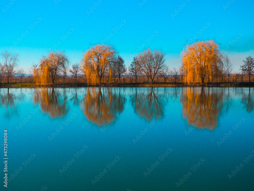 Autumn forest trees are reflected in the lake. North Caucasus.