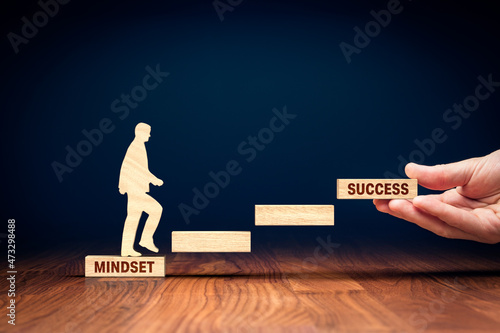 Change mindset lead to be successful. Concept with wooden pieces of blocks and person representing soar to success. Helping hand of coach, mentor or another motivating person. photo