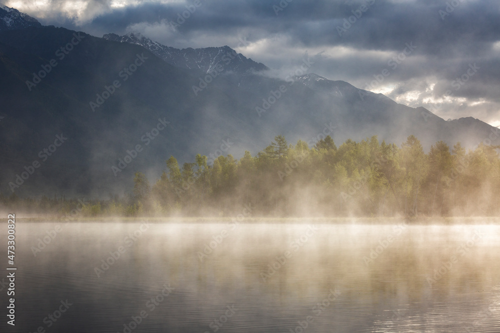 Landscape with mountains reflecting in the water on cloudy summer day. Buryatia, Tunkinskaya valley Landscape with mountains reflecting in the water on cloudy summer day. Buryatia, Tunkinskaya valley