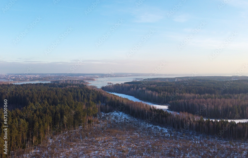 Aerial view of winter snowy landscape with forest and field