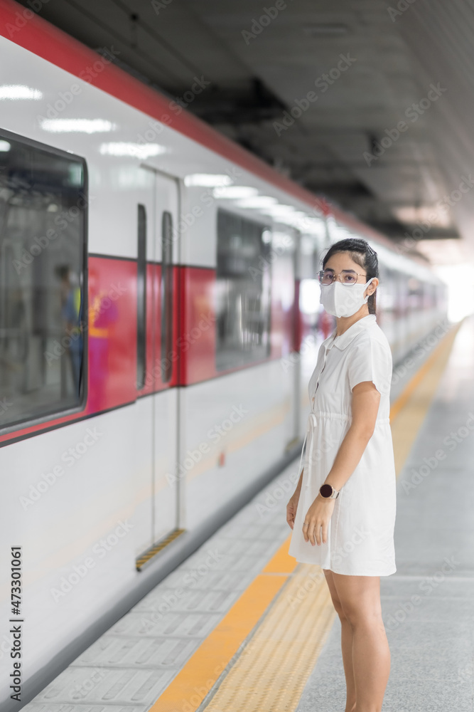 woman wearing Protective face mask prevention coronavirus inflection during waiting train. public transportation. social distancing, new normal and safety under covid-19 pandemic