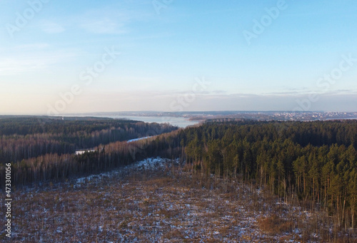 Aerial view of winter snowy landscape with forest and field