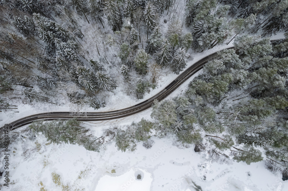 Aerial winter snowy view of forest road