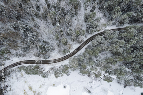 Aerial winter snowy view of forest road