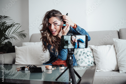 Influencer applying mascara at home studio