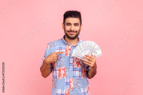Fotografia, Obraz I have big money! Portrait of rich young adult man pointing at dollar banknotes and looking with happy expression, financial savings