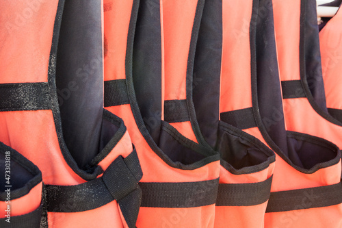 Close-up of orange life jackets in a row photo