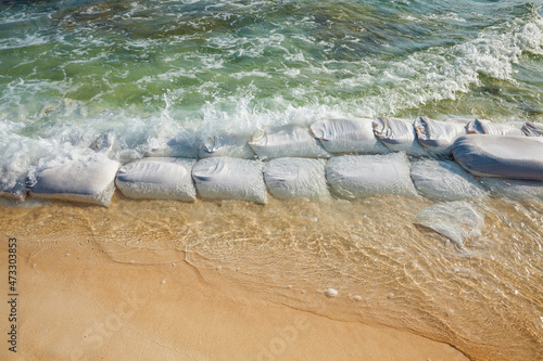 Sandbags in rows at the water's edge to prevent erosion of the beach photo