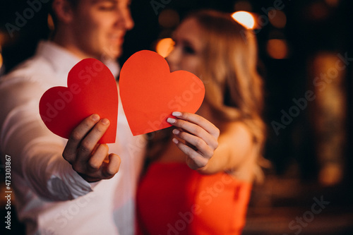 Couple holding paper hearts on valentines day