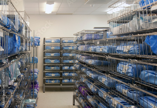 Storage room in a modern hospital, rows of sterile equipment packs in blue fabric. 