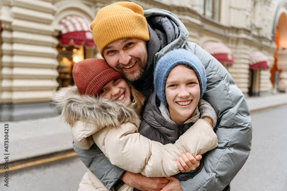 Happy father embracing children at city street Happy father embracing children at city street