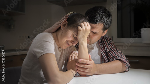 Young man consoling and comforting his upset crying woman suffering from depression and stress
