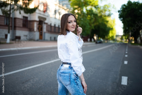Beautiful girl in jeans and a white blouse. © Artsiom P