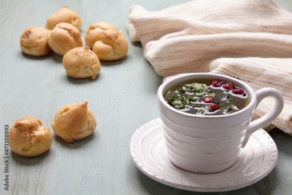 ppetizing profiteroles with whipped cream and a cup of herbal tea