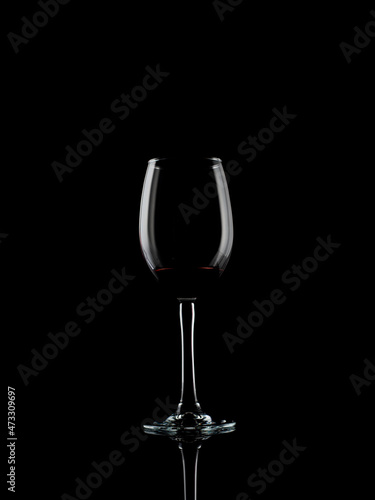 
wine and champagne glass on black background with pouring red wine