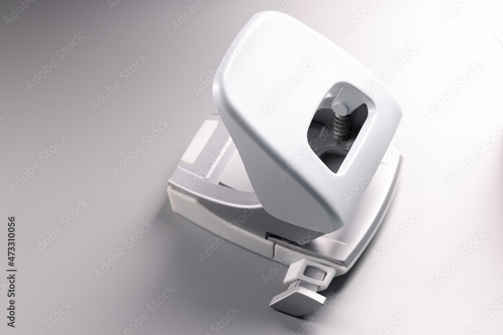 Naklejka premium Closeup of white hole punch on gray background
