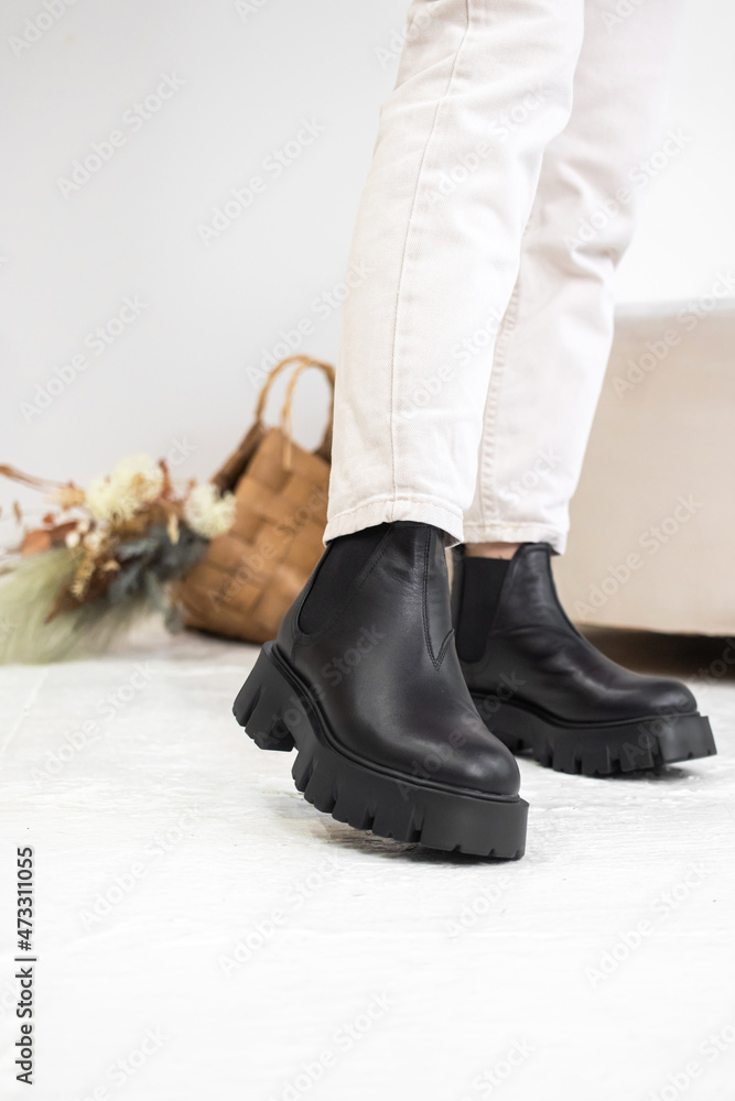 Close-up black winter shoes. Women's leather boots in studio. Casual style, lifestyle fashion concept photo Close-up black winter shoes. Women's leather boots in studio. Casual style, lifestyle fashion concept photo