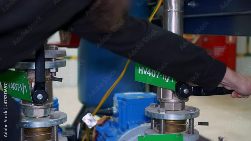 Close-up of the closing of the valve supplying liquid to the pump. Oil and gas industry and production. Work at an oil refinery. Closing the feed valve at the plant. Close-up of the closing of the valve supplying liquid to the pump. Oil and gas industry and production. Work at an oil refinery. Closing the feed valve at the plant.