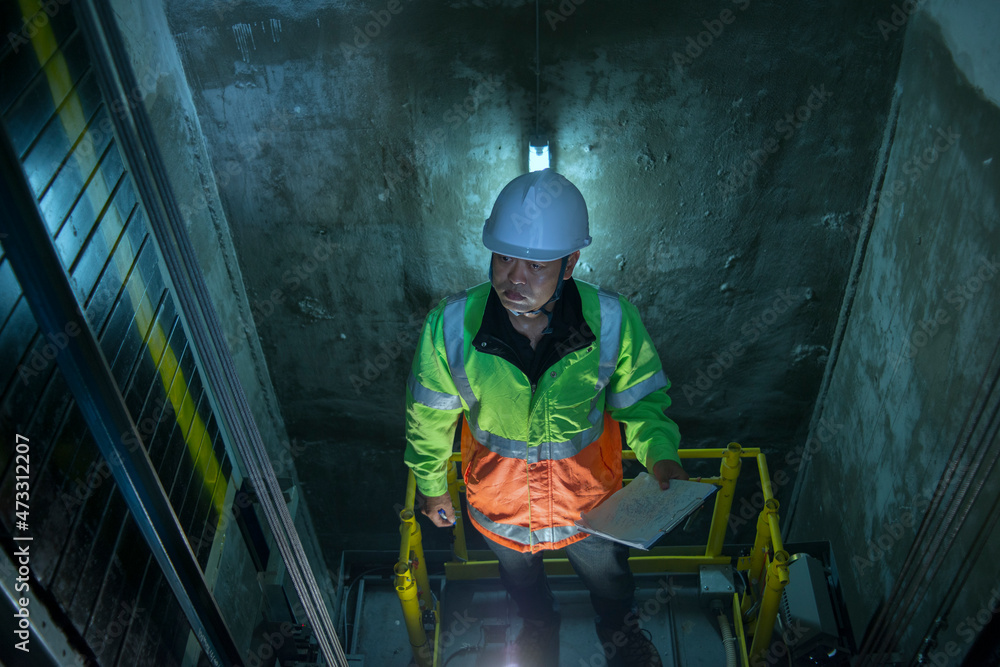 People in elevator shaft. service engineer checking inspector part of