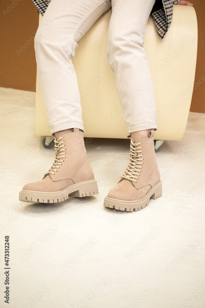 Stylish woman in beige shoes, leather boots, studio shot. Casual lifestyle, fashion girl photo