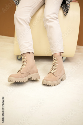 Stylish woman in beige shoes, leather boots, studio shot. Casual lifestyle, fashion girl photo