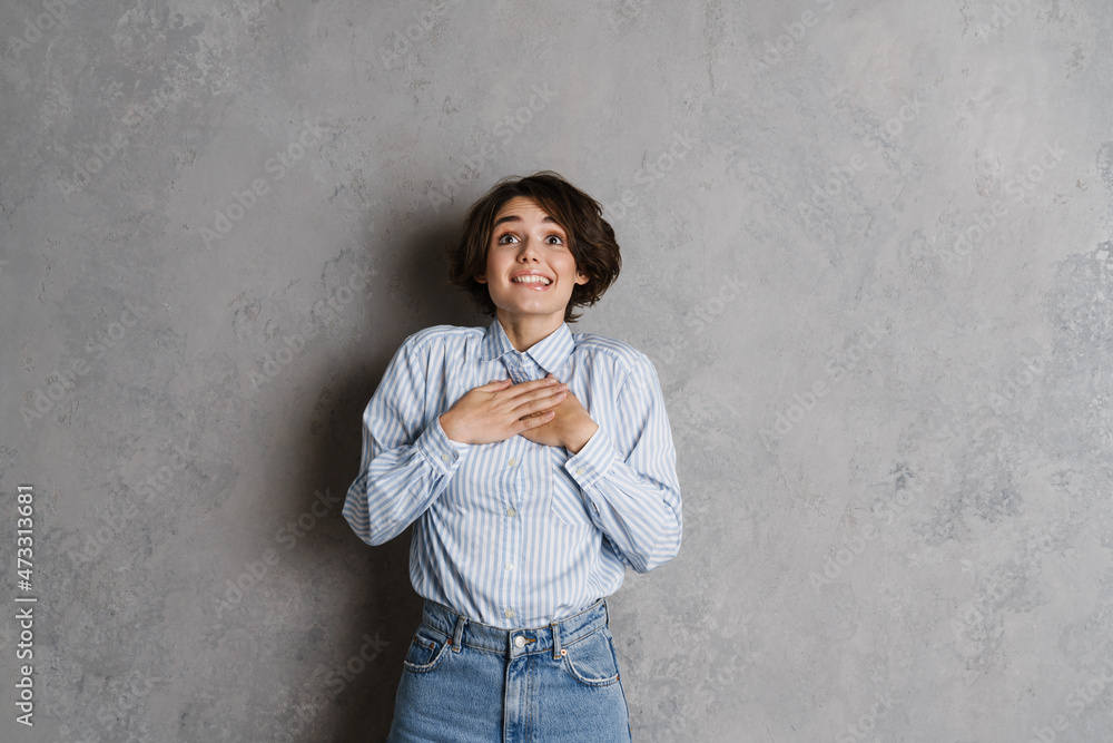 Young brunette woman smiling and holding hands on her chest