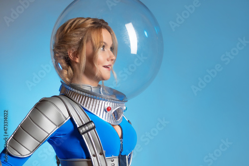 A young woman in a spherical glass helmet, personal air, isolation from the external environment, concept. Fantastic astronaut costume in retrofuturism style.