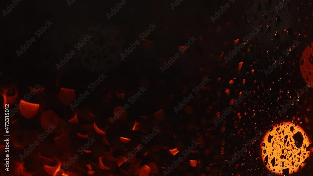 The defocused multicolored lights move slowly through the wet glass. Abstract background with bokeh and beautiful blur. The defocused multicolored lights move slowly through the wet glass. Abstract background with bokeh and beautiful blur.