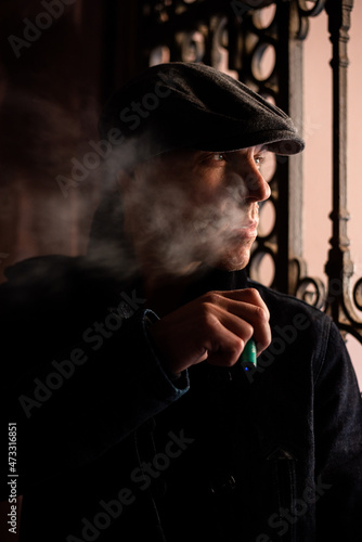 A man in a coat and cap walks around the city.