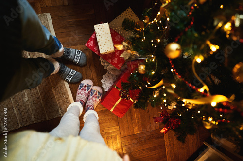 Top view Couple in Christmas socks near decorated xmas tree with gift and present boxes. Winter holiday Xmas and New Year concept