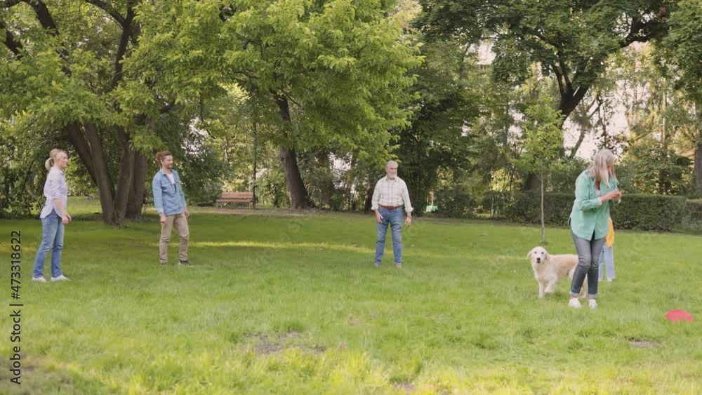 Full length view of the happy family playing at the frisbee at the park with their cute dog. People and leisure concept Full length view of the happy family playing at the frisbee at the park with their cute dog. People and leisure concept