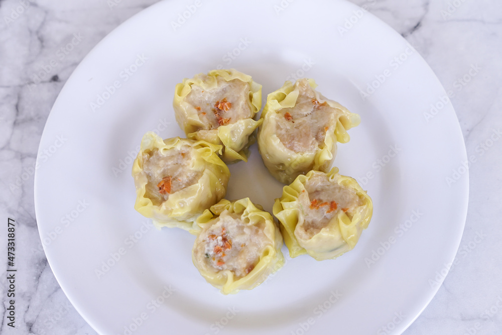 Japanese chicken dumplings Gyoza with carrot and vegetables, on a white plate Japanese chicken dumplings Gyoza with carrot and vegetables, on a white plate